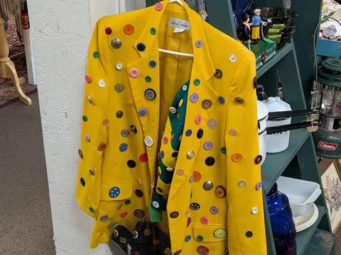 Bright yellow jacket covered in multicolored buttons Stock Photos