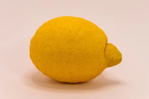 A bright yellow lemon, captured in a studio setting, highlights its texture a Stock Photos