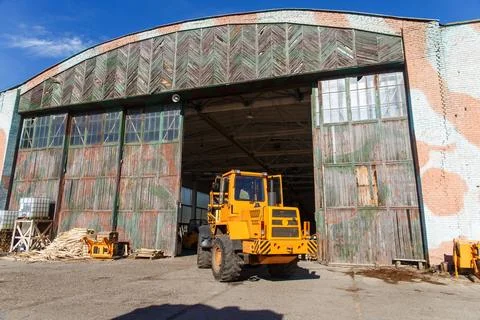 Bright yellow loader parked at an open warehouse Stock Photos