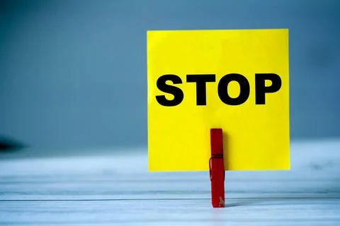A bright yellow note with the word STOP written in bold black letters, attached 스톡 사진