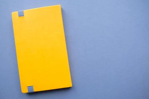 Bright yellow notebook on a solid dark background Stock Photos