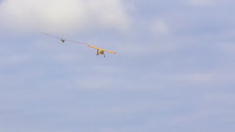 Bright yellow plane pulls glider on cable, accelerating it to required speed so Stock Footage 235491512