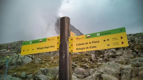 Bright yellow signs pointing in different hiking directions, Pontos, Spain Stock Photos