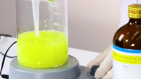 Bright Yellow Solution Stirring in Lab Beaker Stockbeeldmateriaal 307473367