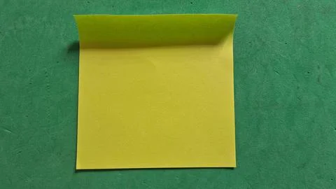 Bright yellow square sticky note placed on a green surface Stock Photos