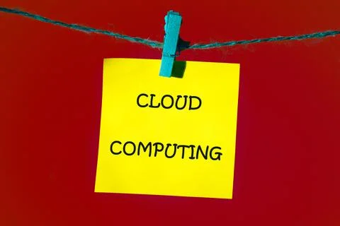 A bright yellow sticky note with cloud computing in bold black hangs on twi.. Stock Photos