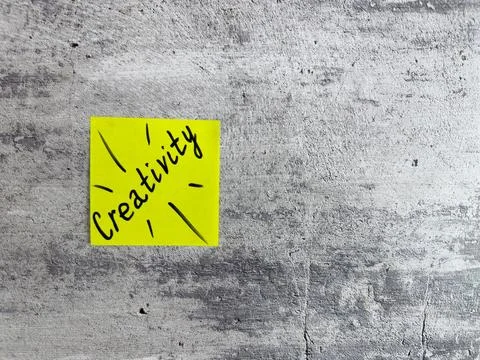 Bright yellow sticky note displaying the word Creativity with decorative elem 스톡 사진