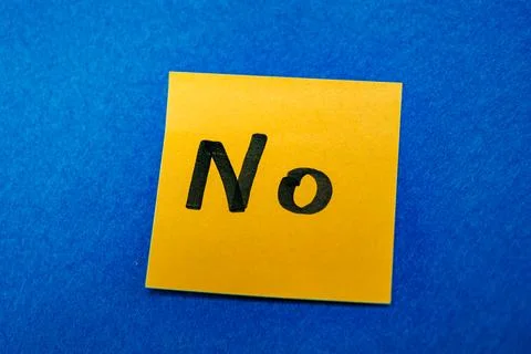 Bright yellow sticky note with handwritten word No on blue felt background, refu Stock Photos
