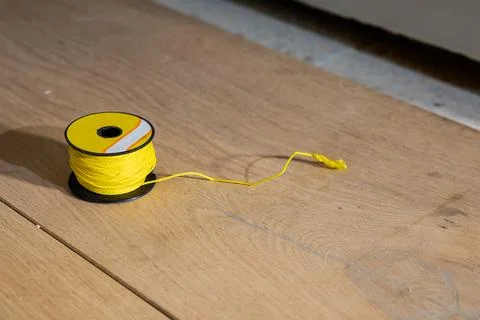 Bright Yellow String Spool on Light Wooden Surface in Workshop 스톡 사진