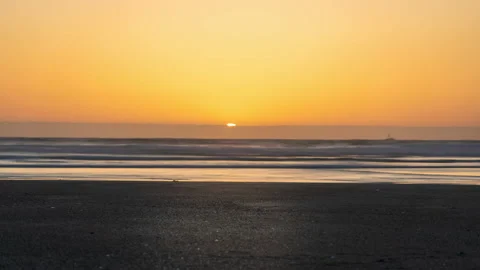 Bright yellow sun sets over the horzion from orange sky - timelapse Vídeos de archivo 220521571