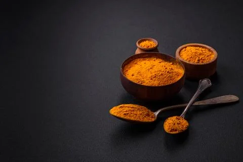 Bright yellow turmeric or curry spice for Asian food preparation Stock Photos