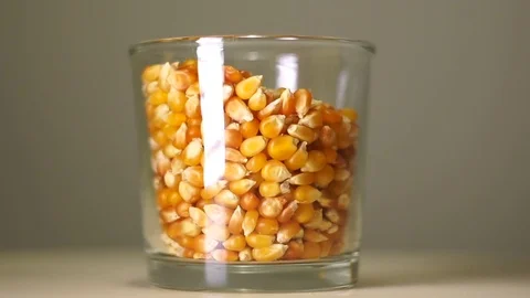 Bright yellow whole kernel corn in transparent glass with white reflection Stock-Footage 75241581