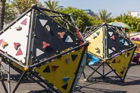 Brightly colored climbing structures sit in a lively outdoor playground sur.. Stock Photos