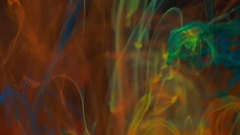 Brightly colored clouds of smoke dance. Hues of yellow, blue, green and red dark 動画素材 247782464