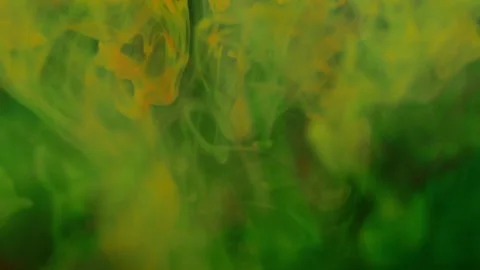 Brightly colored clouds of smoke dance and twist. yellow, blue, green red mix Video stock 247782604