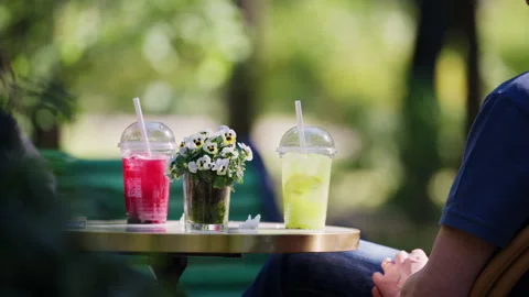 Brightly colored cold beverages displayed on an outdoor cafe table with Stock Footage 337141790