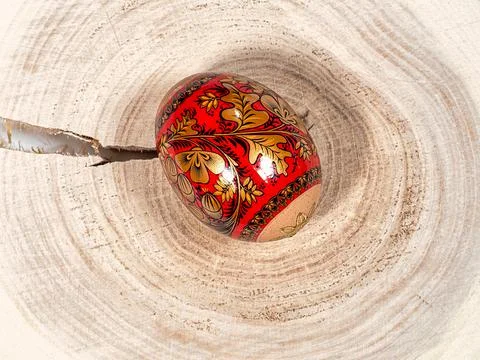 Brightly colored Easter egg with patterns on a wooden background 库存照片