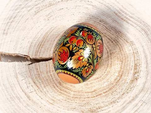 Brightly colored Easter egg with patterns on a wooden background 库存照片