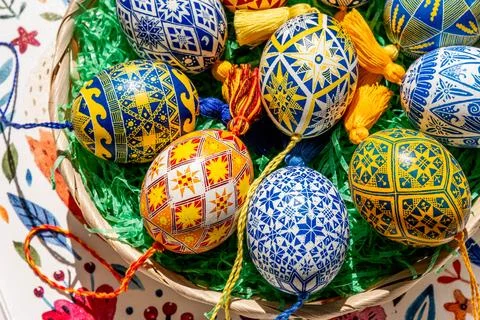 Brightly colored Easter eggs are artistically arranged in an Easter basket, s Stock Photos