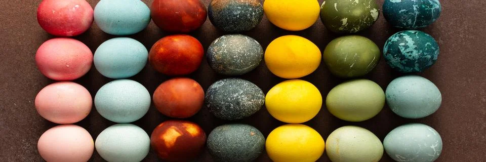 Brightly colored Easter eggs are arranged in a grid, displaying shades like p Stock Photos