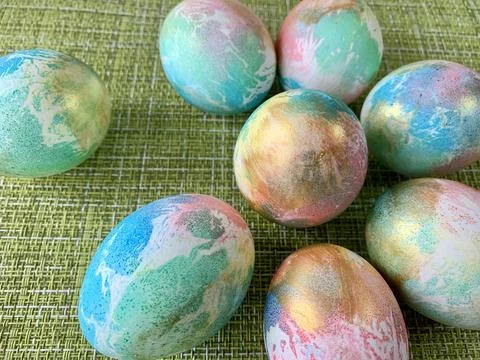 Brightly colored Easter eggs featuring marbled designs are arranged on a vibrant Stock Photos