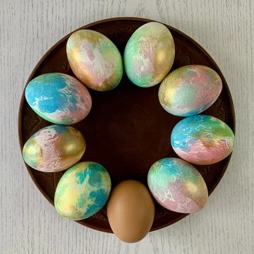 Brightly colored Easter eggs in shades of blue, pink, and gold are arranged in a Stock Photos