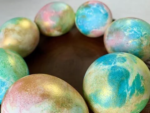 Brightly colored eggs featuring various pastel shades of blue, green, and gold Stock-Fotos