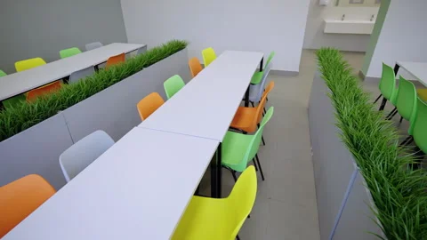 Brightly colored ergonomic chairs alternate along tables Stock Footage 333904574