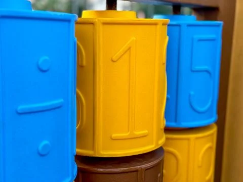 Brightly colored numbers on a play structure at a community park during sunny Stock Photos