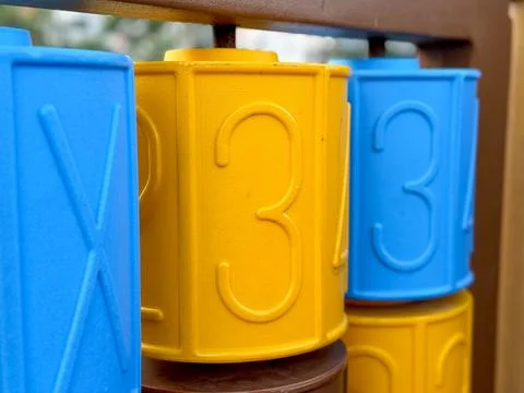 Brightly colored numbers on a play structure at a community park during sunny Stock Photos