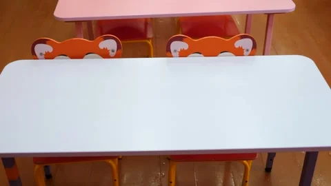 Brightly colored pink and white wooden desks in empty classroom Stock Footage 327590928