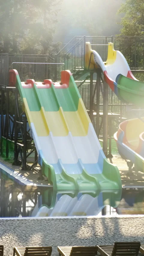 Brightly colored slides lead directly into large swimming pool Stock Footage 320768902