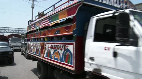 Brightly coloured and packed bus passes thro' busy street scene Stock Footage 39370123