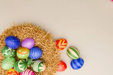 Brightly decorated Easter eggs in and around straw nest Stock Photos