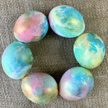 Brightly decorated Easter eggs in pastel shades of pink, blue, and green form a Stock Photos