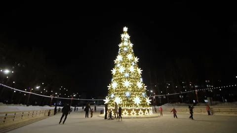 Brightly decorated New Year tree stands in middle of skating rink Stock-Footage 258454944