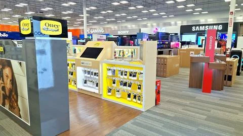 Brightly illuminated electronics store interior with display shelves. Stock Photos
