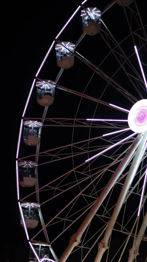 A brightly illuminated Ferris wheel spinning at a Christmas market Stock Footage 293374720