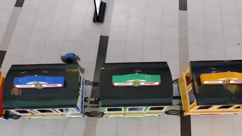 Brightly illuminated mini train attraction displayed indoors at a shopping mall Stock Footage 304052336