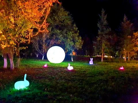 Brightly lighted Colorful Easter egg and rabbits lanterns in a park at night Stock Photos