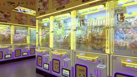 A brightly lit arcade claw machine area filled with plush toys and prizes Stock Footage 337990900