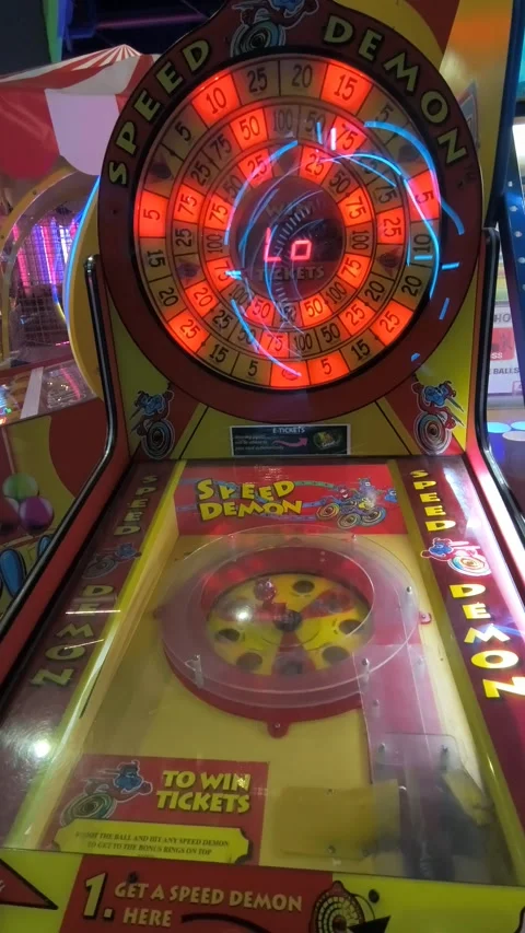 Brightly lit arcade hall featuring electronic game machines and players engaged Stock Footage 331460156