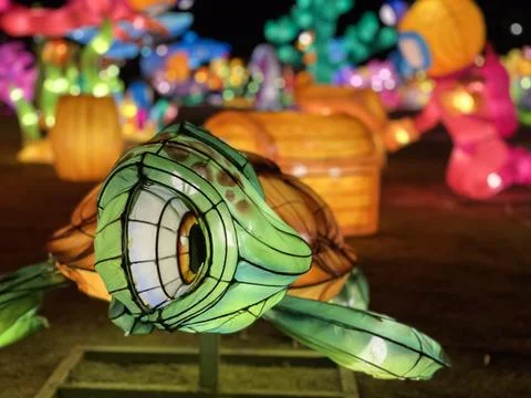 Brightly lit inflatable characters create nighttime fantasy world at park Foto stock