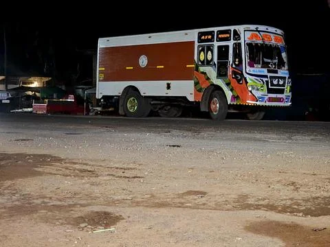 A brightly painted, customized cargo or passenger truck is parked at night Stock-Fotos