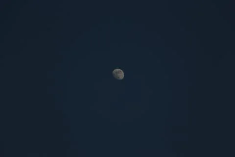 Brightly shining moon in a cloudless night sky Stock Photos