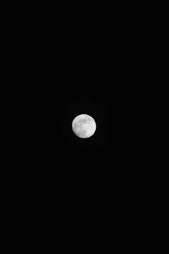 Brightly shining moon in a cloudless night sky Stock Photos