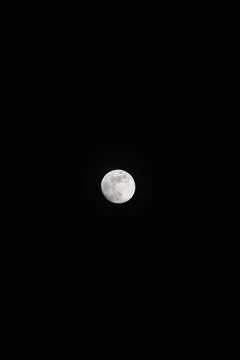 Brightly shining moon in a cloudless night sky Stock Photos