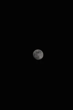 Brightly shining moon in a cloudless night sky Stock Photos