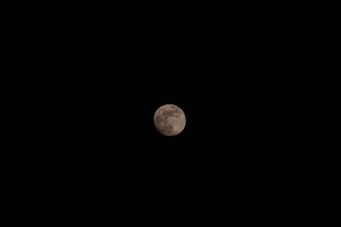 Brightly shining moon in a cloudless night sky Stock Photos