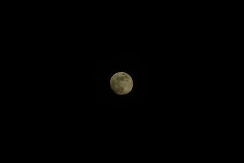 Brightly shining moon in a cloudless night sky Stock Photos